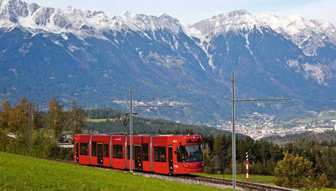 Ein Zug auf einem Gleis mit einem Berg im Hintergrund